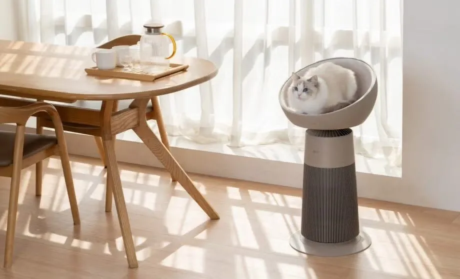 Tháp LG AeroCat Tower màu trắng với một chú mèo đang ngồi trên đỉnh, thể hiện chức năng kép của thiết bị lọc không khí và nơi nghỉ ngơi cho thú cưng.