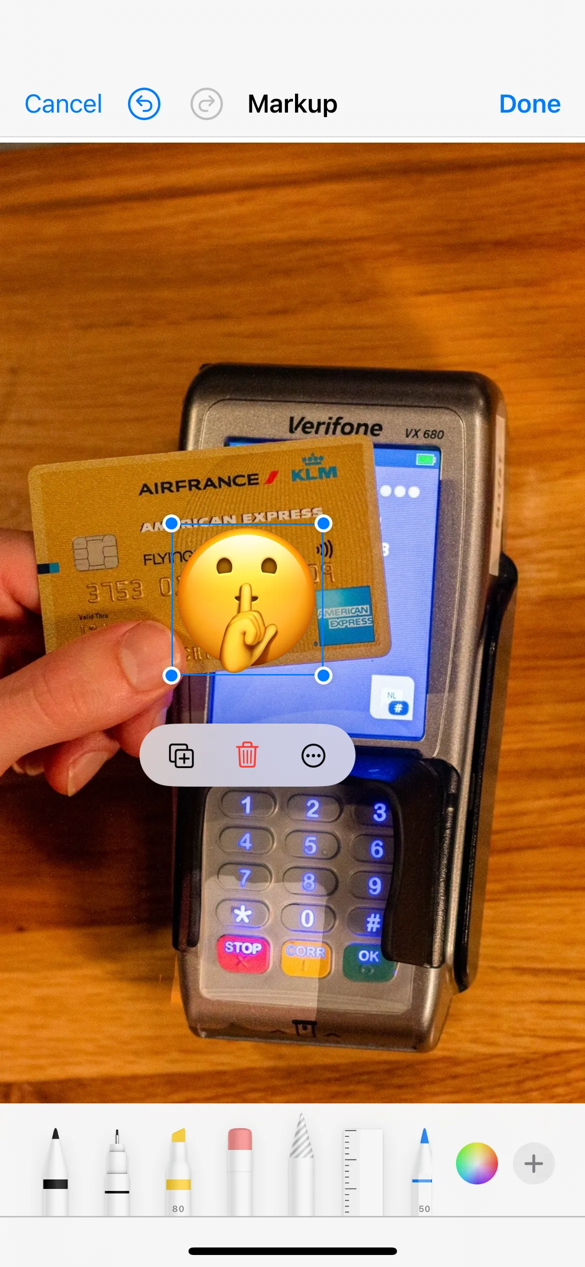 Thẻ tín dụng với số đã được che bằng emoji trong công cụ Đánh dấu của ứng dụng Ảnh trên iPhone