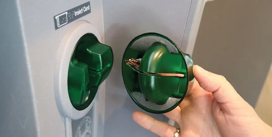 Thiết bị skimming thẻ tín dụng được lắp đặt chồng lên khe đọc thẻ thật tại cây ATM hoặc máy POS.